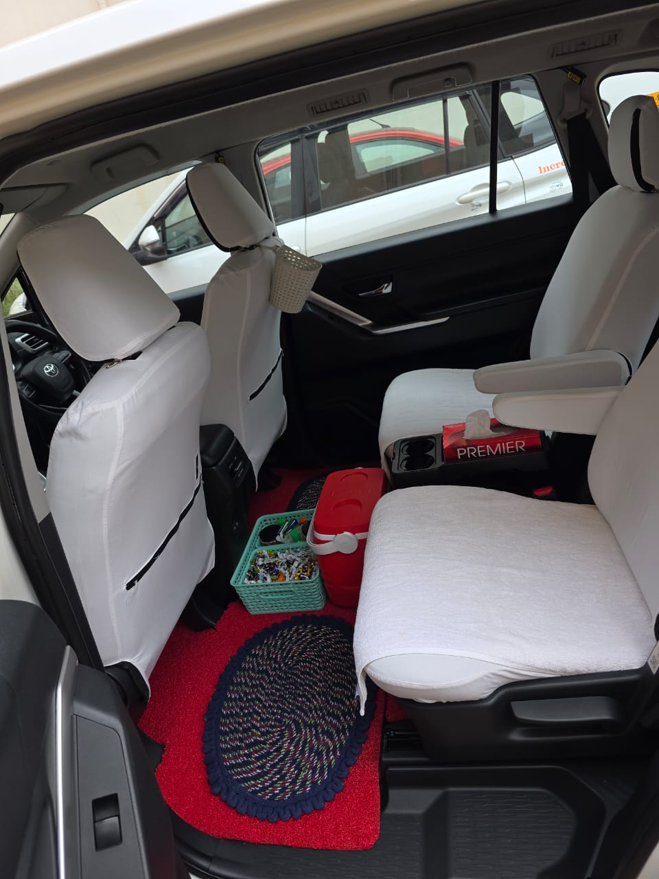 Rear passenger seats with white covers and armrests