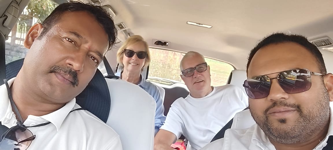 Two guests smiling in the back of the car during a drive