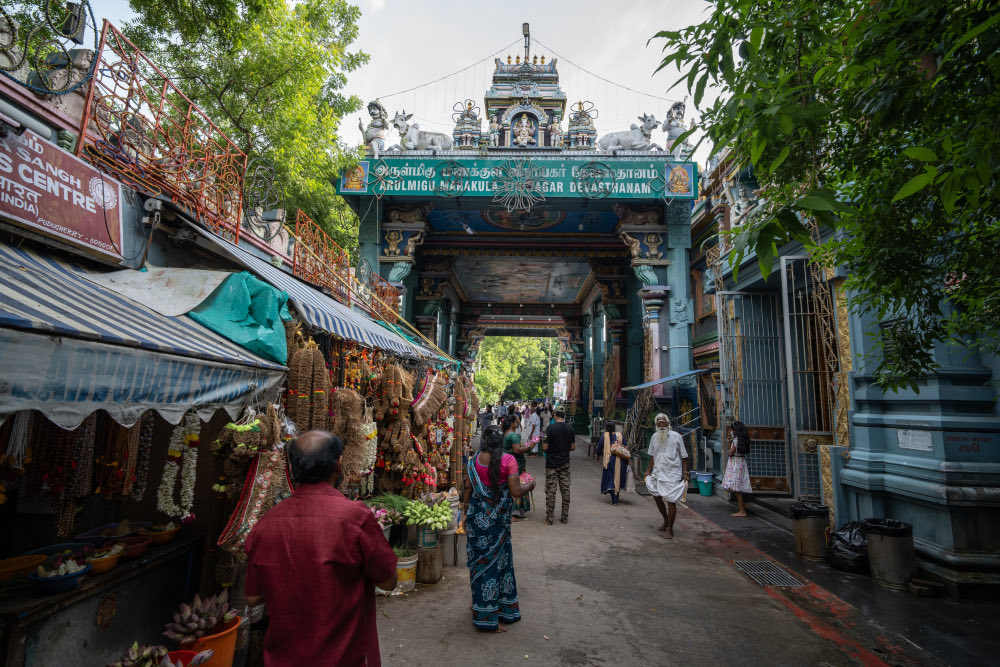 Garland sellers on the street beneath the painted gateway of the Manakula Vinayagar temple, Puducherry